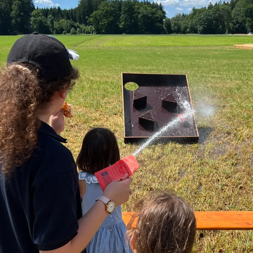 Mit dem Wasserstrahl muss der Ball ins Loch befördert werden